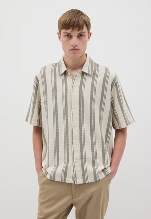 Camisa de botones de manga corta en beige con rayas verticales verdes y negras. Elaborada con tejido texturizado, cuenta con cuello y un corte relajado.