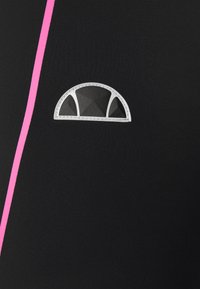 Czarna tkanina z różowym pionowym paskiem i logo w kształcie półksiężyca z geometrycznym wzorem w odcieniach szarości i bieli. Skoncentrowano się na nowoczesnym wzornictwie.