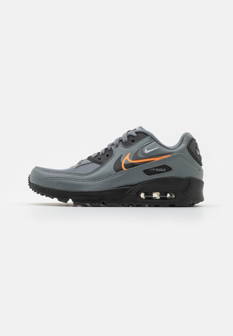 Baskets Nike Air Max grises et noires avec logos Swoosh orange et blanc et coussin d'air visible dans la semelle, vue latérale sur fond blanc.