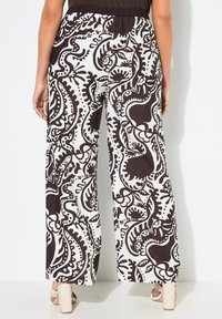 Zwart-witte wijde broek met een spiraalvormig paisley-patroon, gemaakt van lichte stof, met een elastische tailleband en een enkellange snit.