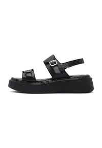 Black leather platform sandals featuring dual straps with buckle accents, a flat sole, and a textured insole for added comfort.