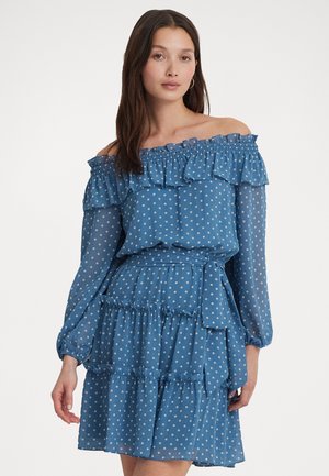 Blaues Kleid mit Polka-Dots, Off-Shoulder-Rüsche, langen Ärmeln, gestuftem Rock und Stoffgürtel. Durchsichtiges Material mit sanfter Textur.