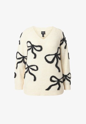 Cremfarbener Pullover mit V-Ausschnitt, der mit schwarzen, flauschigen Schleifenmotiven versehen ist. Der Stoff hat eine weiche Textur und einen legeren Schnitt.