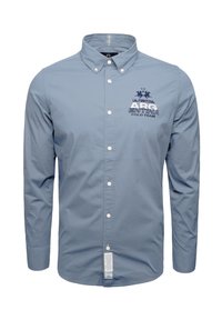 Blue cotton long-sleeve polo shirt with a button-down collar, featuring logo and text embroidery on the chest. Noticeable front buttons.
