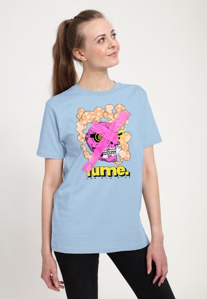 Světle modré tričko s krátkým rukávem má grafický design s růžovou lebkou obklopenou bublinkami a růžovým křížem, doplněné výrazným textem.