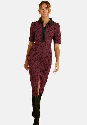 Bordeauxfarbenes Schmeichelkleid mit kurzen Ärmeln, schwarzem Kragen, Polka-Dot-Muster, Schlitz vorne und einer Knopfverschluss entlang des Oberkörpers.