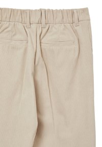 Pantalons en velours côtelé beige avec une texture côtelée. Présentent une taille élastique et deux poches arrière. Fini lisse avec des détails de coutures subtils.