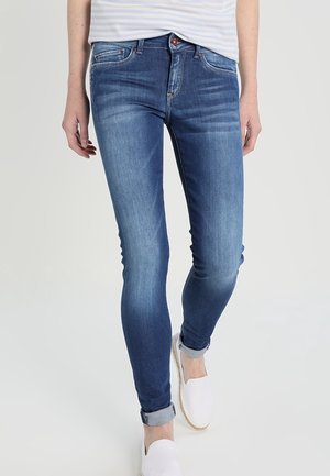 Jeans ajustados de color azul en un lavado medio, elaborados en denim con un ligero desgaste, que cuentan con un clásico diseño de cinco bolsillos y dobladillos enrollados.