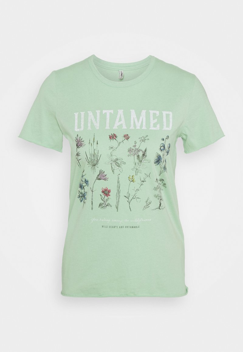 T-shirt en coton vert clair avec le mot "UNTAMED" en blanc, accompagné d'illustrations florales et de texte en dessous, dans une coupe décontractée.