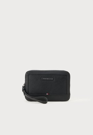 Schwarze Leder-Clutch mit einer strukturierten Oberfläche, rechteckiger Form und einem Handgelenkriemen. Sie verfügt über ein Logo-Emblem und einen kleinen dreifarbigen Akzent.