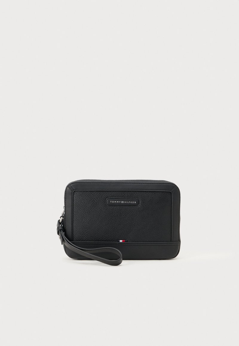 Mustast nahkklamber, tekstureeritud pinnaga, ristkülikukujuline ja randme rihmaga. Omab logosilti ja väikest triivärvi aktsenti.