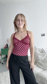 Burgundy linne med vita prickar, med spetsdetaljer och spaghetti-remmar; kombineras med vida svarta byxor.