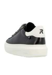 Sneaker en cuir noir avec un talon blanc, présentant des lacets texturés et une semelle épaisse blanche. Logo "R" notable à l'arrière.