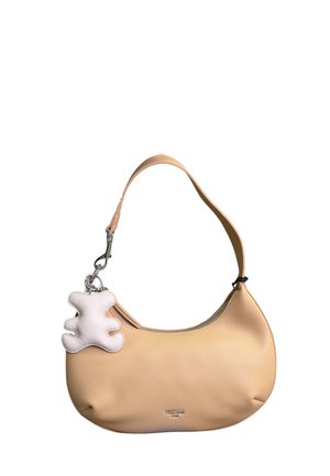 Borsa a tracolla in pelle beige con manico curvo e portachiavi bianco a forma di orsetto attaccato vicino alla cerniera.