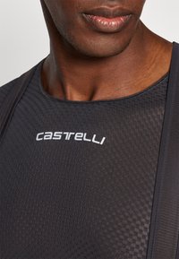 Melnas velosipēdu kreklas ar teksturētu, elpojošu audumu. Ievietots baltais "Castelli" logotips uz krūšu daļas un regulējamas siksnas.