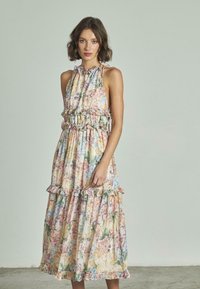 Abito maxi floreale in colori pastello con dettagli arricciati, scollatura a halter e vestibilità ampia. Realizzato in tessuto leggero e testurizzato.