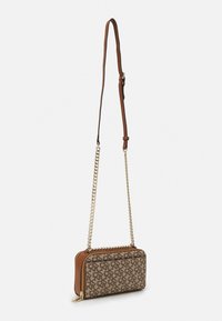 Brązowa torebka na ramię z wzorem, z skórzaną podstawą, łańcuszkiem i skórzanym paskiem, zamkiem błyskawicznym oraz geometrycznym wzorem na głównej powierzchni.