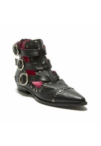 Stivaletto alla caviglia in pelle nera con punta appuntita, caratterizzato da ampie cinghie, dettagli con anelli circolari e interno rosa a contrasto. Presenta dettagli borchiati.
