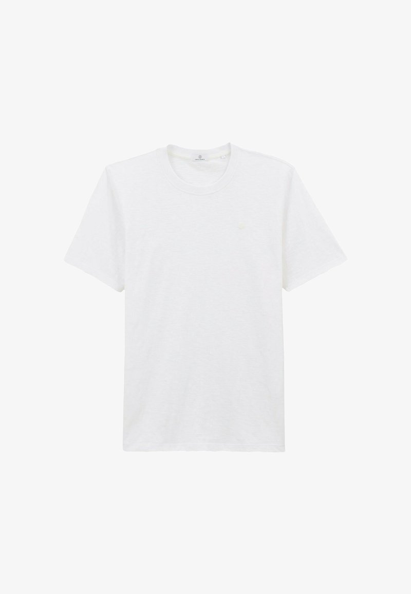 T-shirt blanc à manches courtes et col rond, avec un petit logo circulaire sur la poitrine gauche, présenté sur un fond blanc.