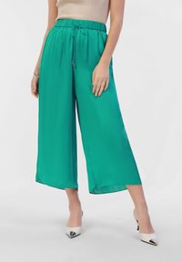 Groene, lichtgewicht, cropped wijde broek met een elastische tailleband en een trekkoorddetail. Soepele textuur en vloeiende ontwerp.