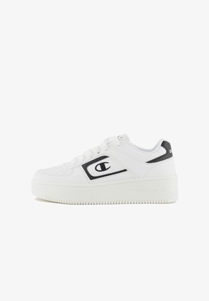 White sneakers with a smooth leather upper, black accents, rounded toe, flat laces, and a textured, thick sole featuring a logo detail.