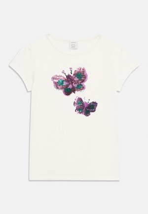 T-shirt blanc à manches courtes avec deux papillons pailletés violets et verts sur la poitrine.