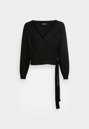 Pull cache-cœur noir à manches longues avec col en V et fermeture par lien sur le côté, présenté sur un fond gris clair.
