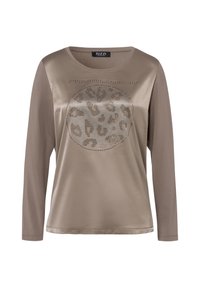 Chemise beige à manches longues, ornée d'un motif léopard rond souligné de clous métalliques. Tissu lisse avec une coupe décontractée et un col rond.