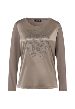 Chemise beige à manches longues, ornée d'un motif léopard rond souligné de clous métalliques. Tissu lisse avec une coupe décontractée et un col rond.