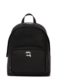 Black textured leather backpack with a top handle, front zip pocket, and a silver cartoon face logo on the front. Zippered closure.