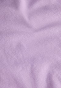 Απαλή μωβ ύφασμα με μαλακή, ομαλή υφή, που παρουσιάζει ένα διακριτικό, ομοιόμορφο σχέδιο ύφανσης και χωρίς ορατές σημάνσεις ή διακοσμητικά στοιχεία.