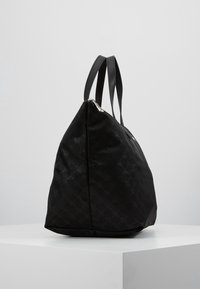 Czarna torebka typu tote wykonana z teksturowanej tkaniny, z podwójnymi płaskimi uchwytami, z zapięciem na zamek błyskawiczny oraz subtelnym wzorem na powierzchni.