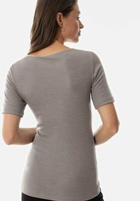 Grey ribbed knit short-sleeve top with a rounded neckline and fitted silhouette, showcasing a smooth texture and subtle vertical pattern.