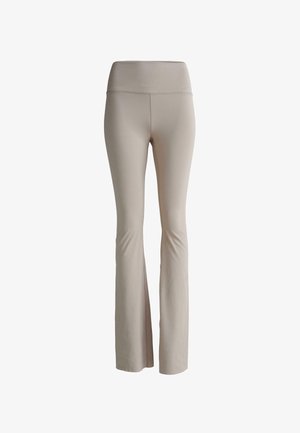 Beige csepp szabású leggings rugalmas anyagból. Széles derékrésszel és sima textúrával rendelkezik, amely a kényelem és rugalmasság érdekében készült.
