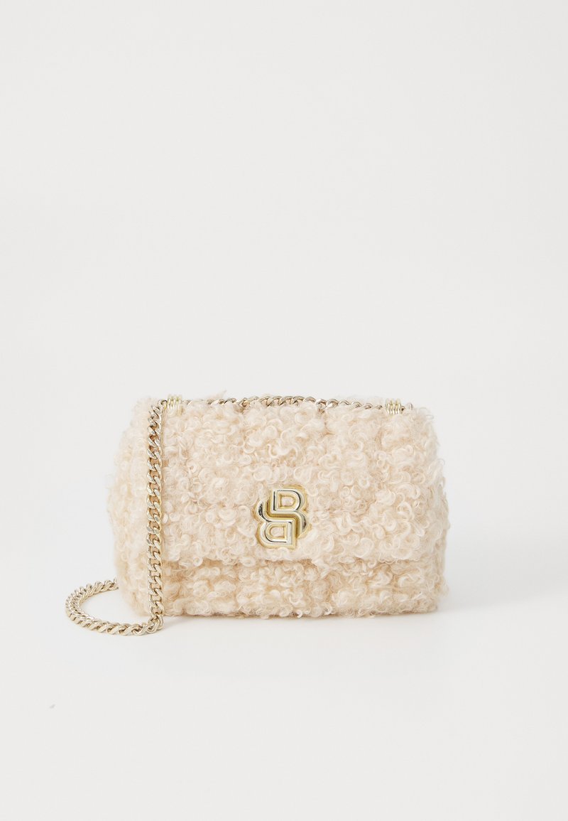 Τσάντα χρώματος κρέμα με υφή τυριού, χρυσή αλυσίδα, και χρυσά εξαρτήματα με λογότυπο. Συμπαγής ορθογώνιο σχήμα.