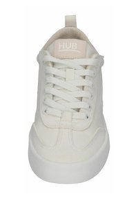 Witte canvas sneaker met een ronde neus, textuur bovenkant, platte veters en een ronde hak. Heeft een licht logo op de tong.