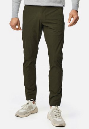 Olivegrøn, slim-fit bukser lavet af et let materiale, med en glat tekstur og minimal detaljer. Sammen med lysegrå sneakers.
