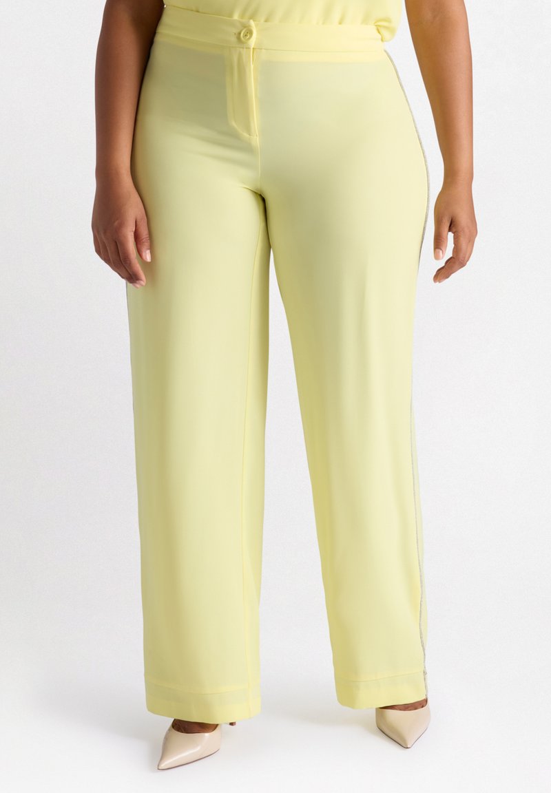 Gelbe weit geschnittene Hose aus glattem Stoff mit Knopfverschluss, Gürtelschlaufen und seitlichen Akzenten mit einem glänzenden Besatz.