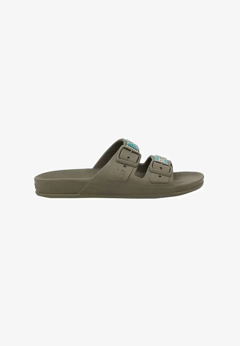 Grønne sandaler med formstøbte såler, der har to justerbare stropper med turkise perleaccenteringer. Flad sål, åbent tådesign og glat tekstur.