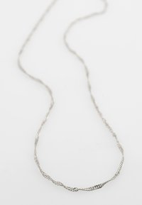 Sudraba vērsta ķēdes kaklarota ar plānu, smalku dizainu. Iezīmēta ar teksturētu virsmu, ko izceļ neliels mezgla elements.