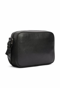 Borsa in pelle nera con superficie texturizzata, forma rettangolare e chiusura con zip. Presenta una tracolla con fibbia e bordi arrotondati.
