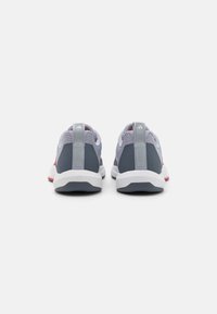 Gray athletic shoes featuring a mesh upper, a white sole, and red accents, with a pronounced heel tab labeled "TRAINING."