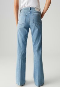 Jeans svasati blu chiaro con vita media, due tasche posteriori e una trama di denim liscia. Presentano cuciture sottili e un'etichetta in vita.