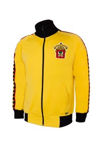 Geel ritsjack met zwarte kraag en manchetten. Kenmerkt een vormgegeven embleem op de borst en decoratieve gestreepte accenten langs de mouwen.