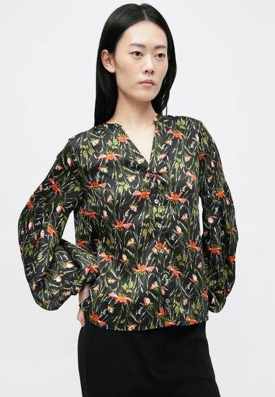 Juodas gėlių bliusonas su ryškiai oranžiniais ir žaliais raštais, V formos iškirpte ir mygtukų užsegimu. Ilgos rankovės su susiraukšlėjimais.