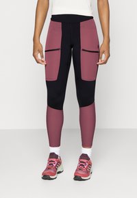 Högmidjade leggings har en kombination av mörkblå och burgundy paneler med dragkedjade framfickor och ett mjukt, stretchigt tyg.
