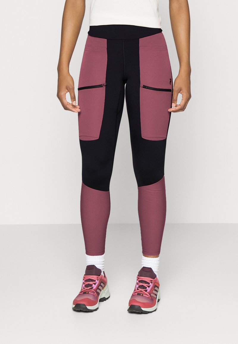 Högmidjade leggings har en kombination av mörkblå och burgundy paneler med dragkedjade framfickor och ett mjukt, stretchigt tyg.