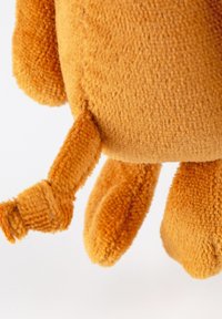 Soft plush toy with orange textured fabric, rounded body, and short limbs. Notable details include stitched accents and a fluffy finish.