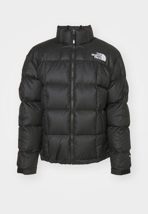 Svart puffjacka med hög krage och dragkedjeslutning. Har quiltade detaljer och elastiska ärmslut. Logotyp tryckt på vänster axel.