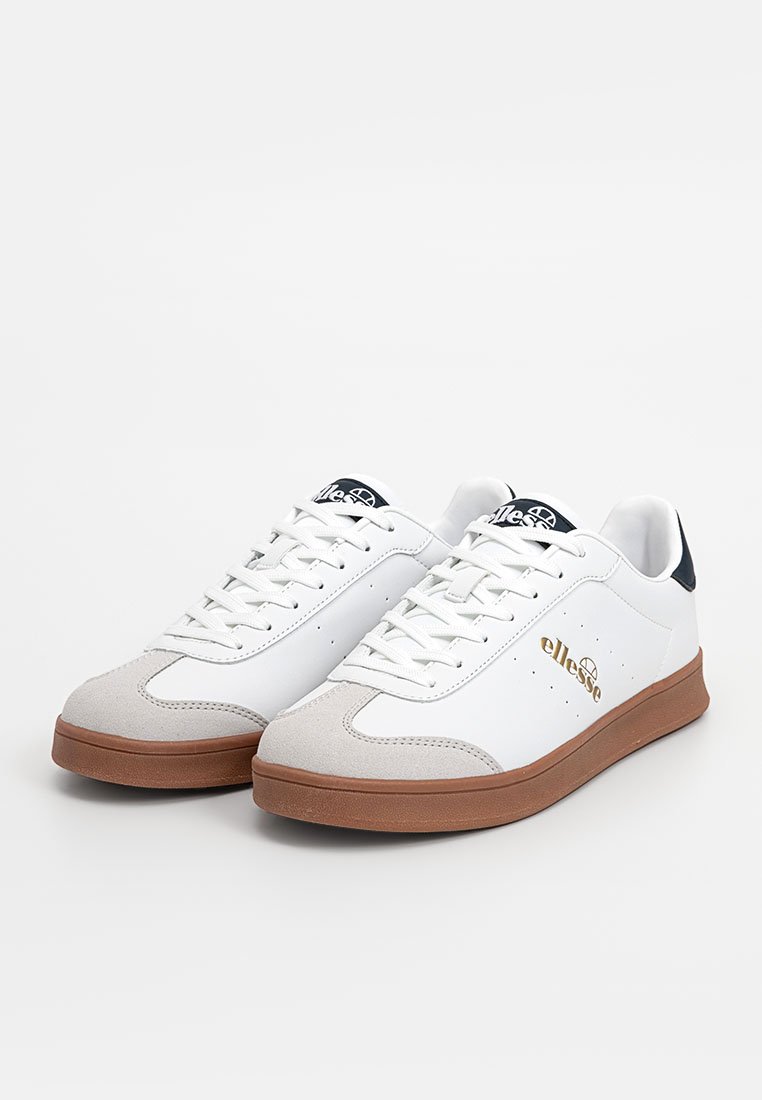 Zapatillas blancas con parte superior de cuero liso, detalles en ante gris y suela de goma marrón. Presentan un logo dorado y un detalle en la lengüeta de color azul oscuro.